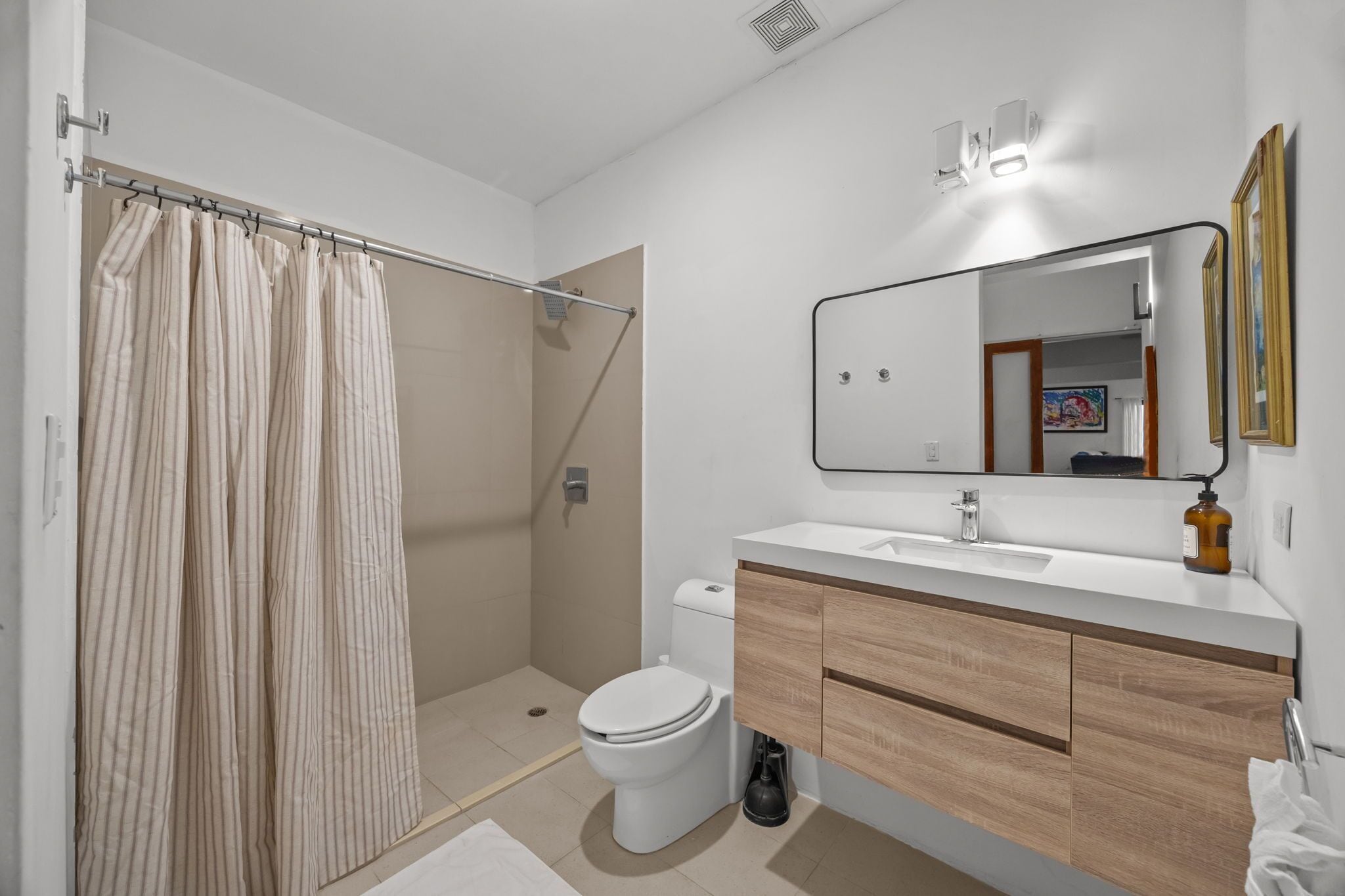 A modern bathroom with a shower, toilet, and sink.