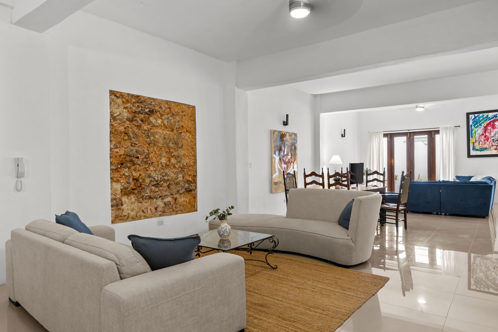 Una sala moderna con sofá, mesa de centro y obras de arte en las paredes.