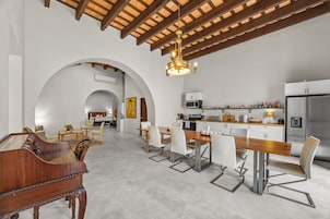 Amplia sala de estar con una mesa de comedor, sillas y una cocina equipada con electrodomésticos modernos.