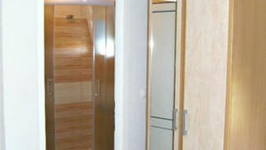 A bathroom with a shower, toilet, and a cabinet.