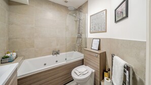 A modern bathroom with a bathtub, toilet, and vanity. - Lace Market - 1-bed Apt - Sleeps 3 - City Centre (Nottingham)