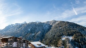 Ein Gebirgsresort mit Holzhäusern, schneebedeckten Bäumen und blauem Himmel.