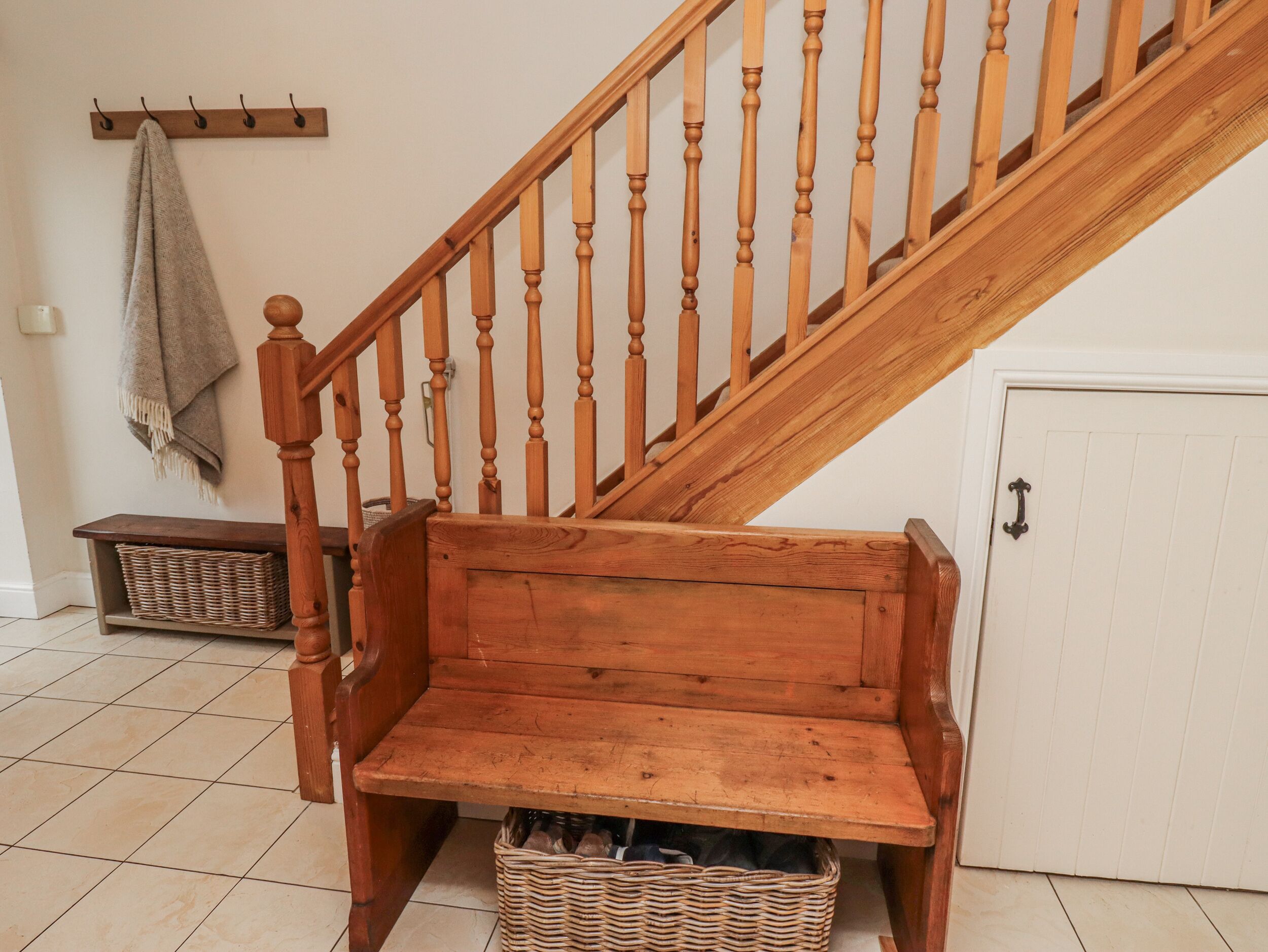 A wooden staircase with a bench at the bottom.