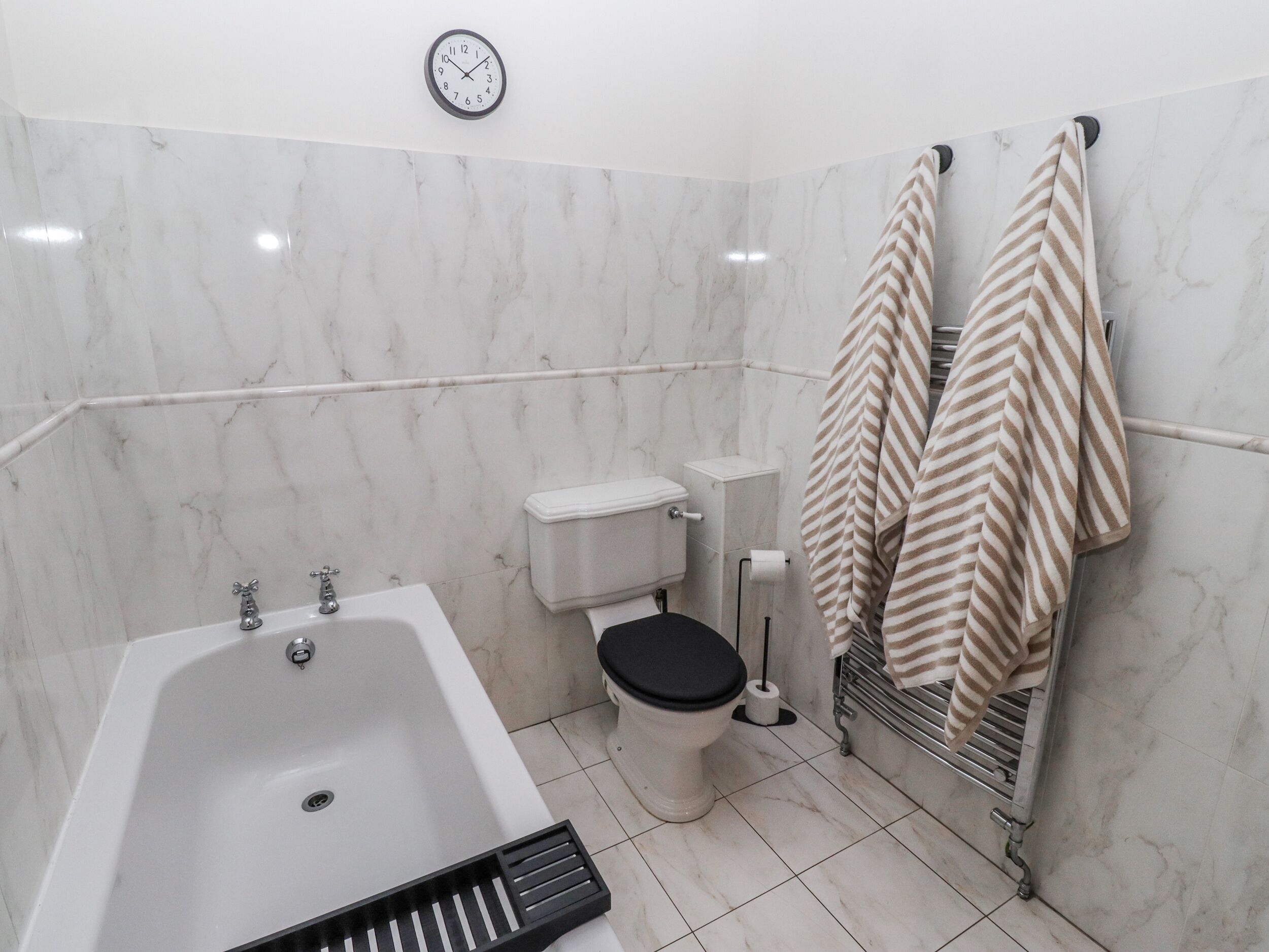 Une salle de bain avec une baignoire, des toilettes et un porte-serviettes.