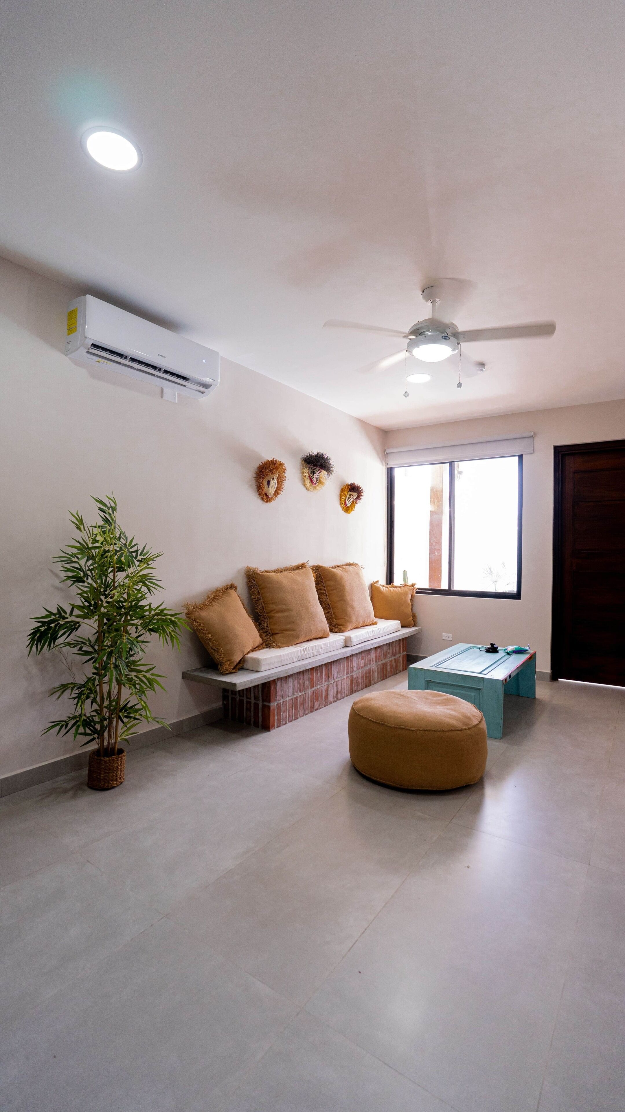 Un salon moderne doté d’un ventilateur de plafond, d’un appareil de climatisation et d’une grande fenêtre.