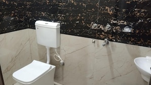 A bathroom with a toilet, bidet, and sink. - MANGAL DHAM DEOGHAR  (Deoghar)