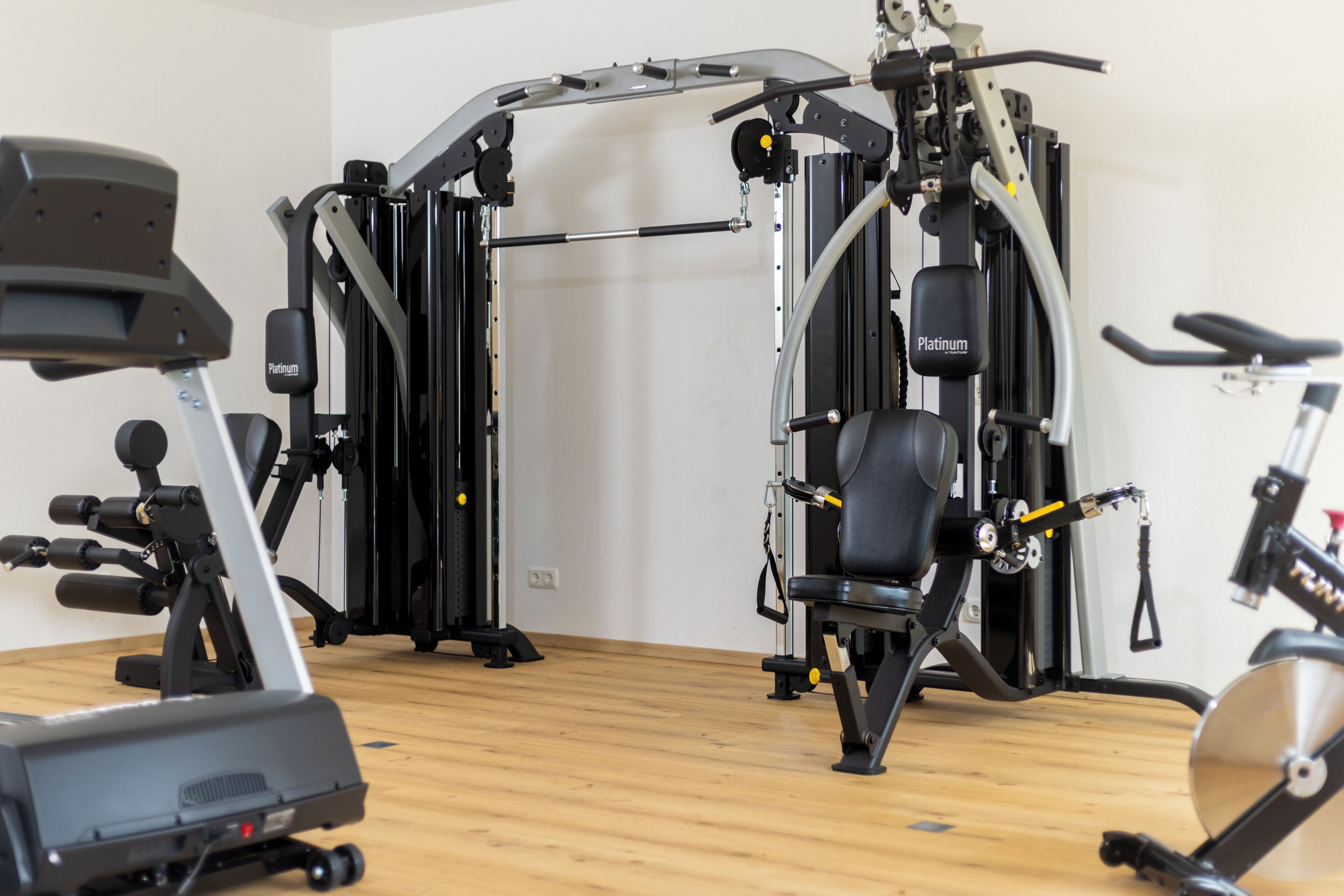 Ett gym med träningsredskap, en bänk och en motionscykel.