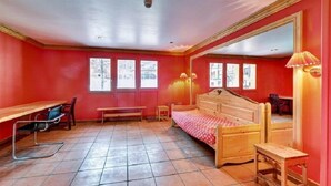Una habitación con cama, escritorio, silla y banco.