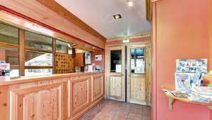 Un mostrador de recepción de madera con una ventana, una puerta y un tablón de anuncios en la pared.