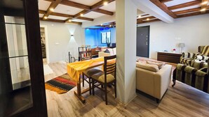 A spacious living area with a wooden ceiling, a dining table with chairs, a sofa, and a striped armchair. - Villa Freya (Sapanca)