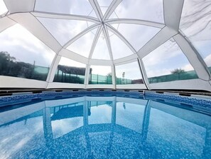 A modern indoor swimming pool with a geometric glass ceiling and clear blue water. - Villa Freya (Sapanca)