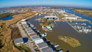 Ein Luftbild eines Hafens mit mehreren Anlegestellen und Booten, umgeben von Wasser und Industriegebäuden.