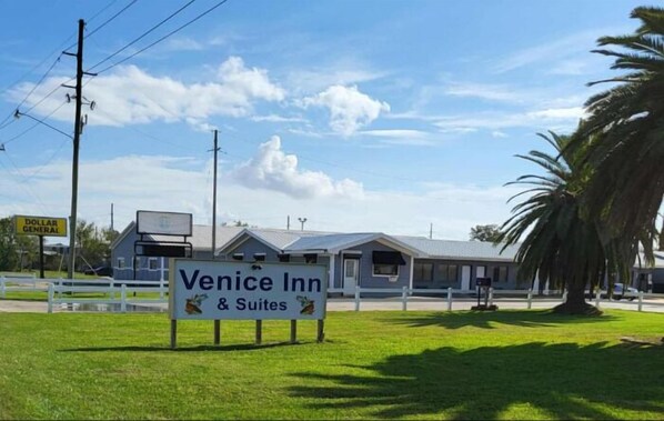 A hotel named 'Venice Inn & Suites' with a signboard in front.