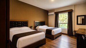 A hotel room with two beds, wooden flooring, a window with curtains, and an air conditioning unit. - Hotel Hacienda Concá (Concá)