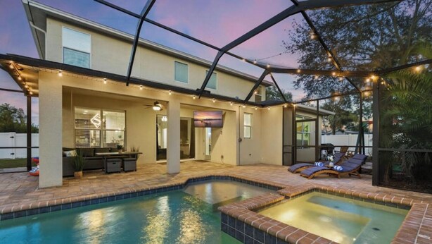 Ein Haus mit Pool, Sitzgelegenheiten im Freien und einer überdachten Terrasse.