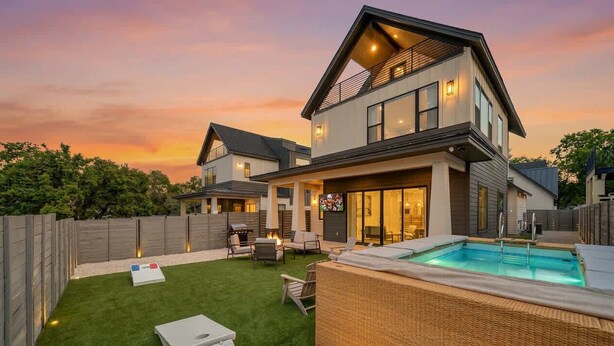 A modern two-story house with a swimming pool, outdoor seating, and a well-maintained lawn. - Luxury Pool Retreat, Game Room, Sleeps 24 (Austin)