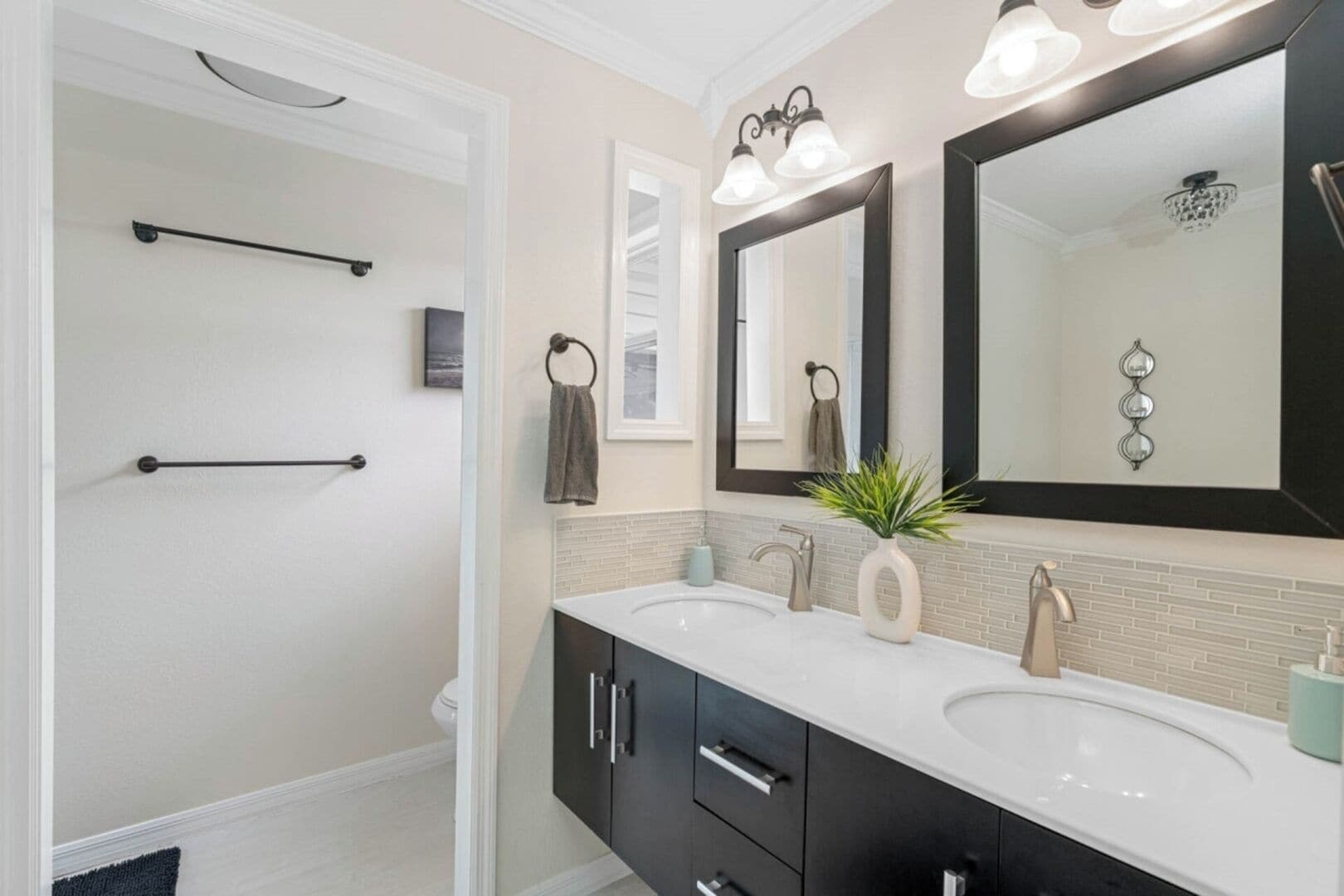 Un bagno moderno con due lavabi, un grande specchio e una zona doccia.
