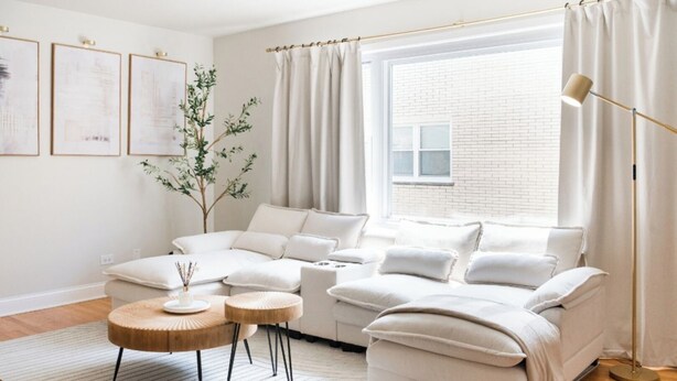 A modern living room with a sectional sofa, a round coffee table, and a floor lamp. - 2BR • Newly Furnished Modern Apt • Near O'Hare (Chicago)