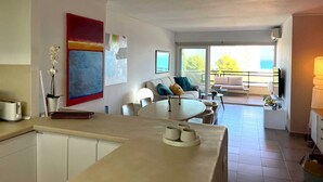 Ein modernes Wohnzimmer mit Essbereich, einer Küche und einem Balkon mit Blick.
