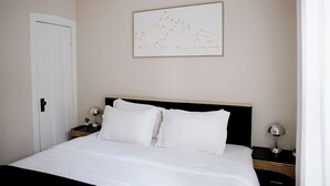 A hotel room with a bed, a nightstand, a lamp, and a wall-mounted picture. - Private Workspace •  Sleeps4 • Modern Stylish Stay (Chicago)