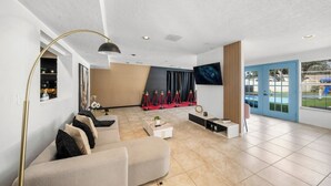 Un vestíbulo de hotel moderno con un sofá, una mesa de centro y un televisor de pantalla plana.