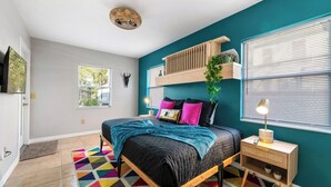 A bedroom with a bed, a nightstand, a window, and a ceiling fan. - Sleeps 25 • Heated Pool• In+Outdoor Games •Theater (Tampa)