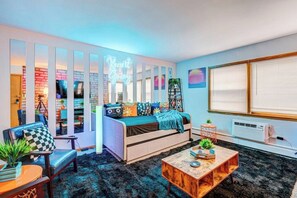Una sala de estar acogedora con un sofá, una mesita de centro y una estantería.