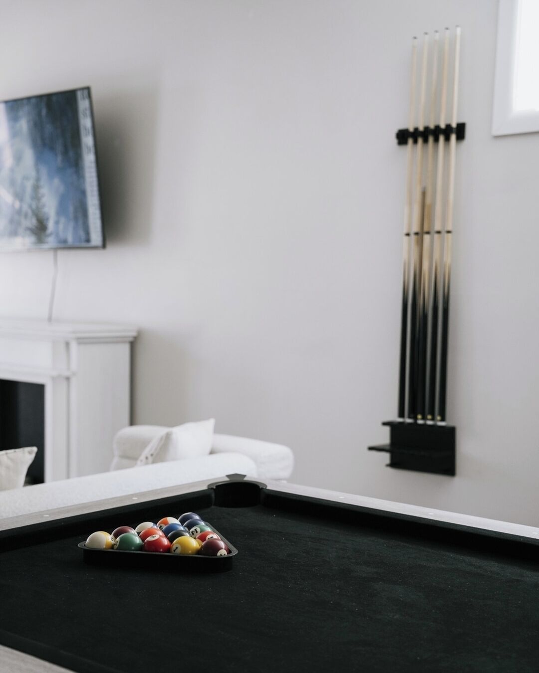 Une table de billard avec un jeu de queues de billard et un plateau de billes.
