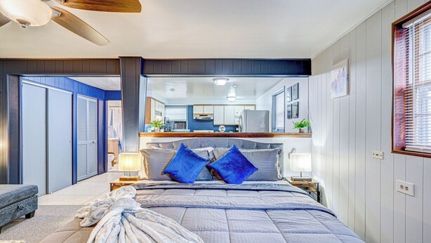 A bedroom with a large bed, a nightstand, a dresser, and a ceiling fan. - King Bed Studio | 60" HDTV | Safe | Close to Metra (Elmwood Park)