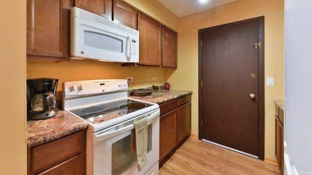 A compact kitchen with a microwave, stove, and oven.