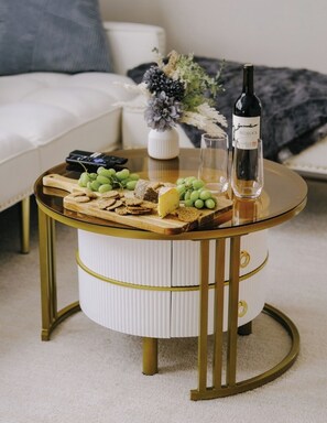 A round table with a wooden board holding cheese, crackers, and grapes, a bottle of wine, and two glasses. - Sleeps 7 •  Huge Projector •  Designated Workspace (Chicago)