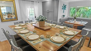 A dining area with a wooden table set for a meal, surrounded by chairs. - Sleeps 40! 13BR•Heated Pool•Waterfront Resort•Spa (Tampa)