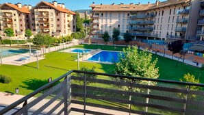 A residential building with multiple balconies and a swimming pool area. - Apartamentos Pilartxo Jaca 3000 (Jaca)