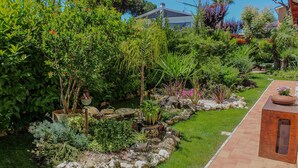 Ein gepflegter Garten mit verschiedenen Pflanzen und einem Pflasterweg.