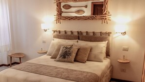 Ein ordentlich bezogenes Bett mit einer gemusterten Decke, ein Kopfteil mit Holzdekor und zwei Nachttischlampen.