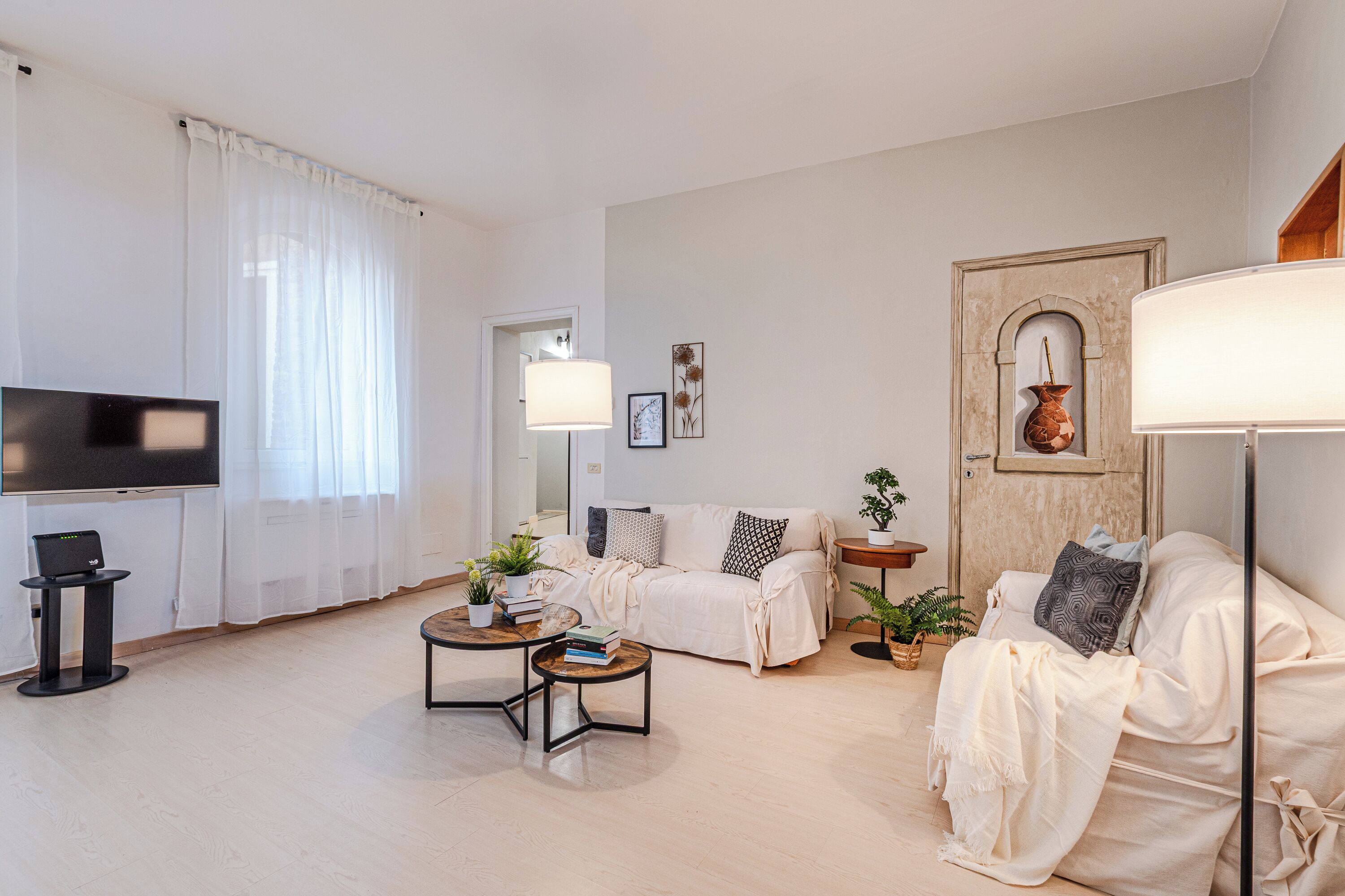 A modern living room with a sofa, coffee table, TV, and decorative items.