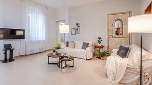 Un salon moderne comprenant un canapé, une table basse, un téléviseur et des objets de décoration.