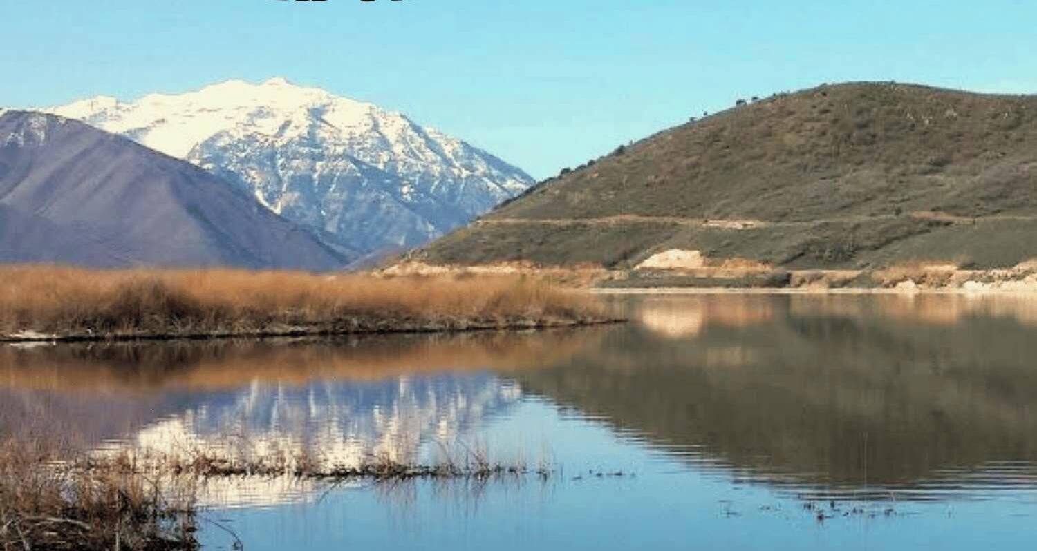 A calm lake with a mountain in the background.