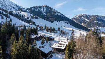 Een besneeuwde bergdorp met houten gebouwen en een piste.
