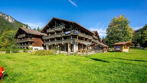 A large wooden building with multiple balconies and a small annex.