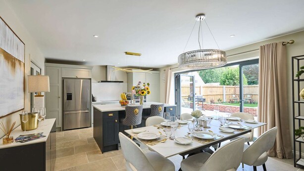 A modern kitchen with a dining area, large windows, and a chandelier. - Host Stay The Sett (King's Lynn)