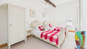 A bedroom with two beds, a wardrobe, and a bedside table. - Host Stay Dolphin Dream (Berwick-upon-Tweed)