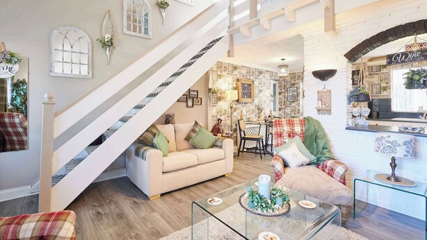 A spacious living room with a staircase, a dining area, and a kitchen with a wine sign. - Host Stay The Cheeky Squirrel (Wallasey)