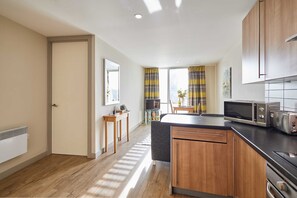 A modern kitchen with wooden cabinets, a black countertop, and a microwave. - Host Stay 508 Hatton Garden (Liverpool)