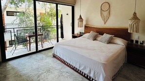 A bedroom with a large bed, a ceiling fan, a macrame wall hanging, and a view of the outdoors. - Jungle  Studio Balcony & Hammock S19 (Tulum)