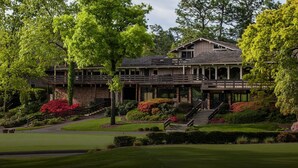 A large, multi-story building with a covered porch and a staircase leading to the entrance. - Pine Needles Lodge & Golf Club (Southern Pines)
