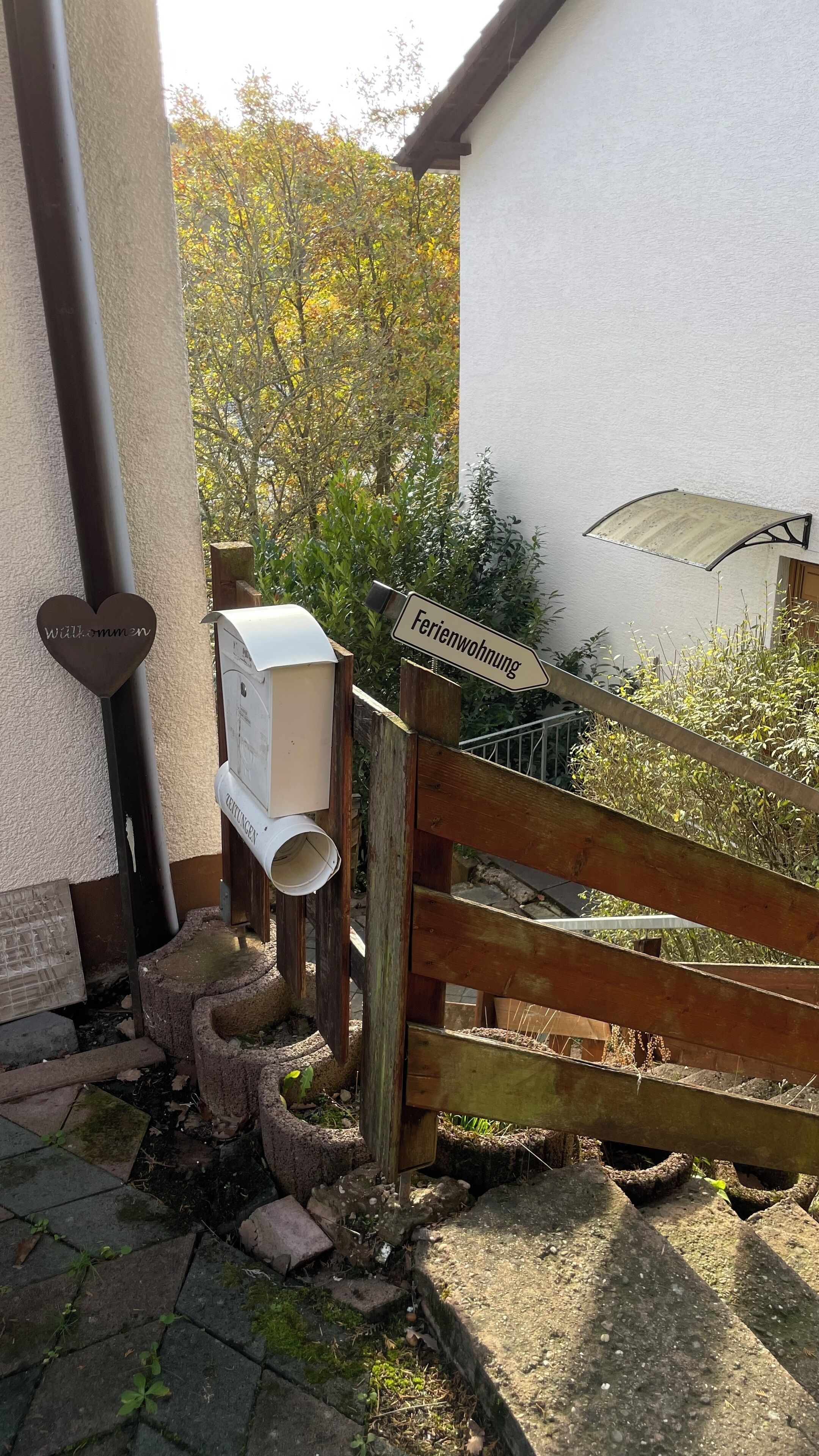 Une porte en bois avec une pancarte indiquant « Ferienwohnung » et une boîte aux lettres.