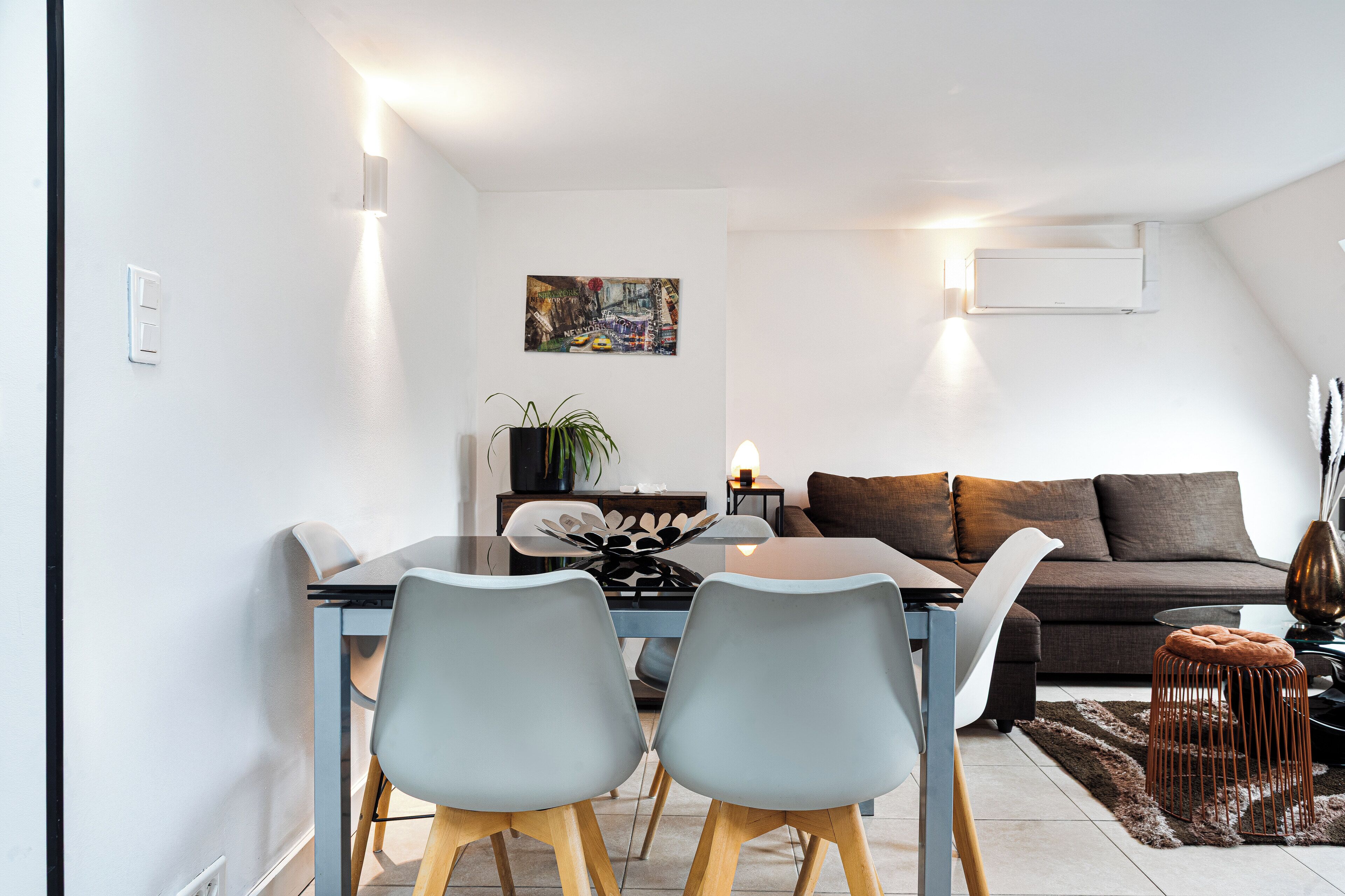 Un salon moderne avec un coin repas, comprenant un canapé, une table basse et une table à manger avec des chaises.