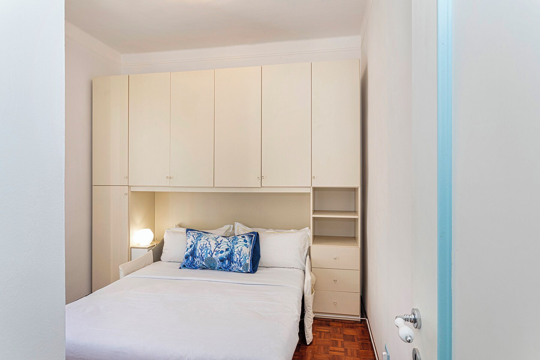 Un dormitorio con cama, mesita de noche, cómoda y armario.