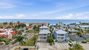 A coastal residential area with houses, a beach, and a clear view of the ocean. - 8BR Luxe Retreat w/ Pool, Spa & Rooftop Deck, Beach + Bay Views, Walk to Beach (Bradenton Beach)